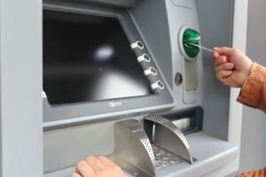 Photo of a person using a debit card at an ATM depicting a situation where a consumer may need an electronic funds transfer act attorney to correct transaction errors.