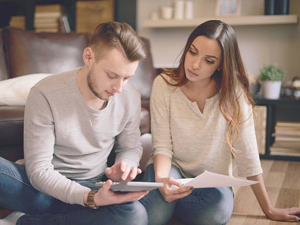 A man helping a woman go through a credit report